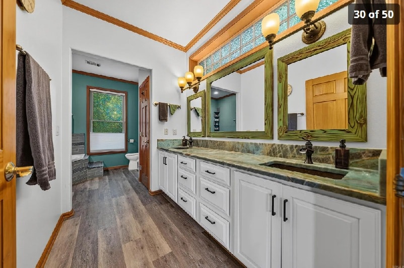 Primary bath with double vanity, green granite counters, and stained glass transom
