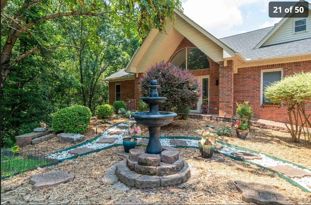 Front exterior of 139 Waterfront Ct — brick facade, arched window, and fountain garden