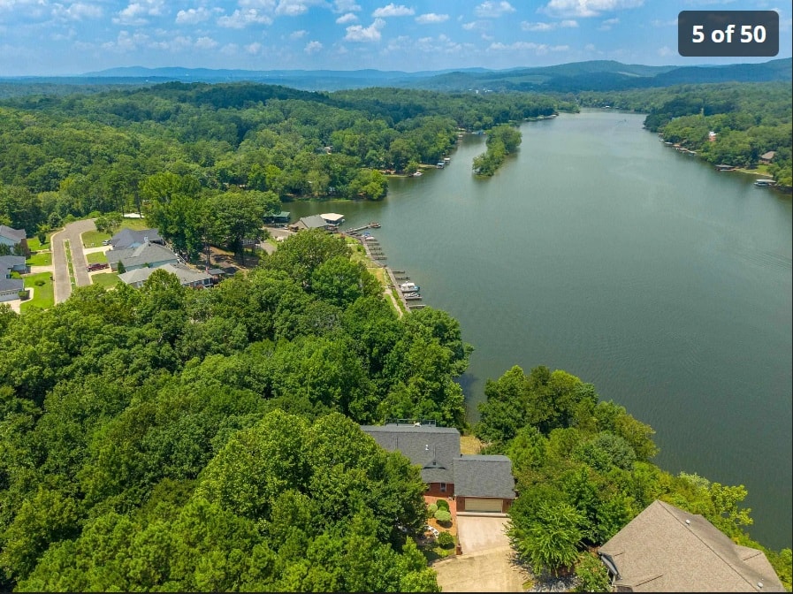 Aerial view of 139 Waterfront Ct nestled on the water with Ouachita Mountains backdrop