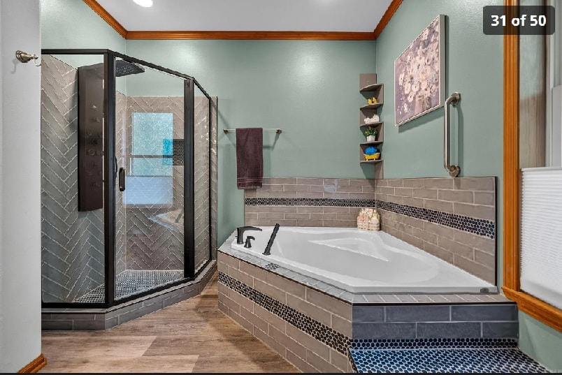 Primary bath with soaking tub, herringbone tile shower, and spa finishes